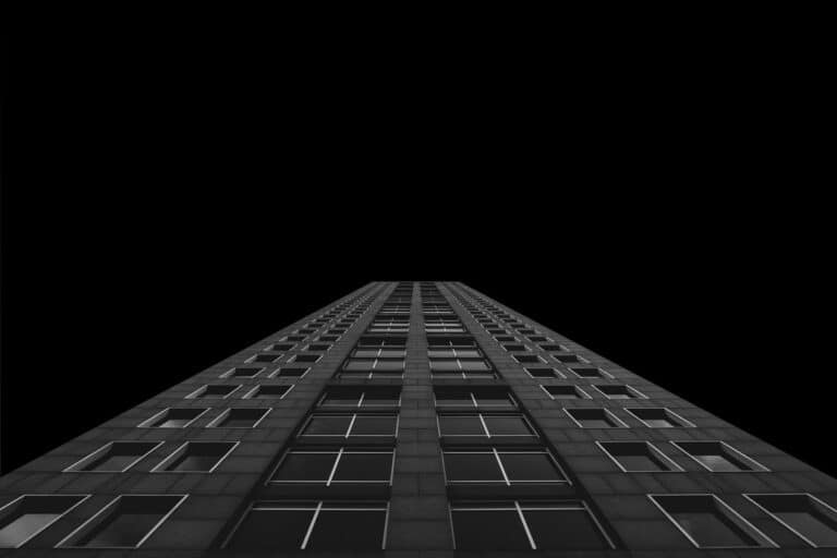 Architecture moderne noire d'un immeuble à multiples étages qui illustre la hauteur, l'ambition et les étapes à franchir.